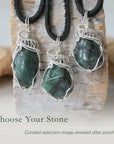 Three emerald pendants for men showing natural variation in size, shape, and green colour with sterling silver wire wrapping.