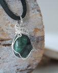 Right angle view of emerald necklace for men showing natural raw emerald and detailed 925 sterling silver wire wrapping.