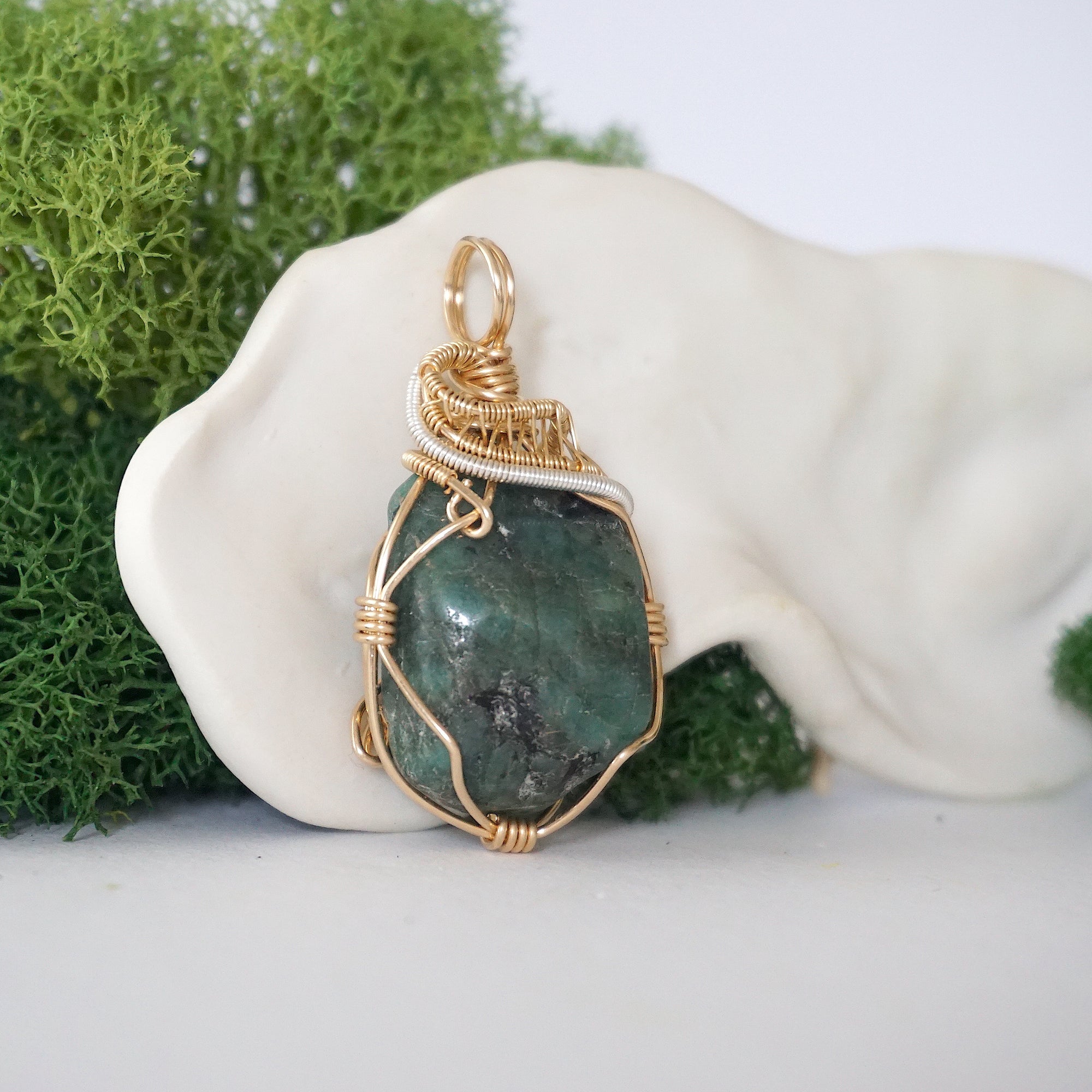Right angle detail of emerald pendant for women showing natural polished-raw emerald and artisan 14k gold filled and sterling silver wrapping