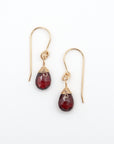 Top view flat lay of garnet 14k gold filled drop earrings showing wire wrapped faceted garnet crystals and fish hook ear wires