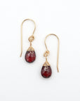 Top view flat lay of garnet 14k gold filled drop earrings showing wire wrapped faceted garnet crystals and fish hook ear wires