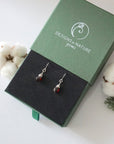 Garnet sterling silver drop earrings in branded Designs by Nature Gems jewelry box, showcasing handcrafted faceted garnet and sterling silver wire wrapping