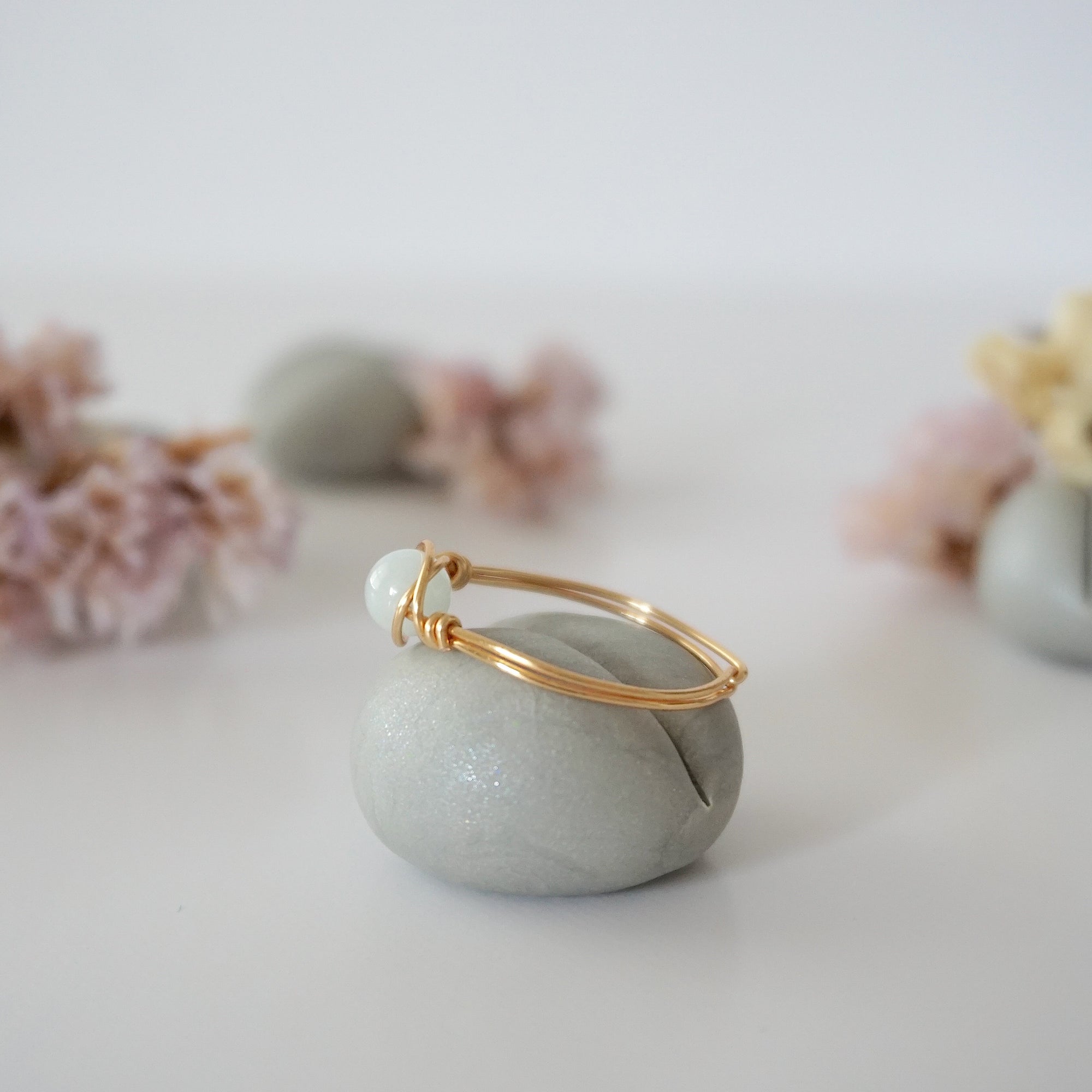 Side angle of gold aquamarine ring, artisan wire wrapped, minimalist design