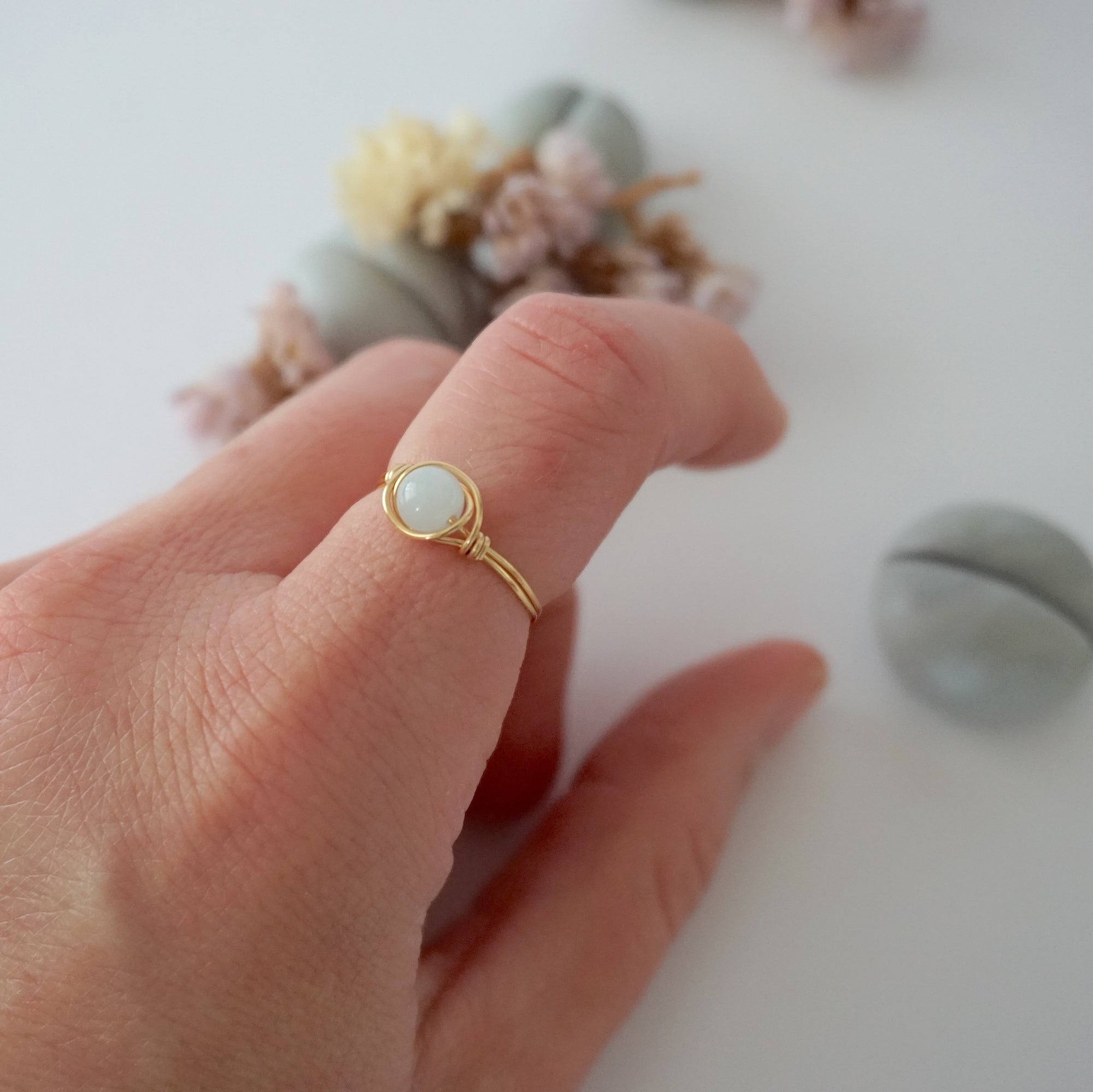 Minimalist gold aquamarine ring on female model's hand, handcrafted, Designs by Nature Gems