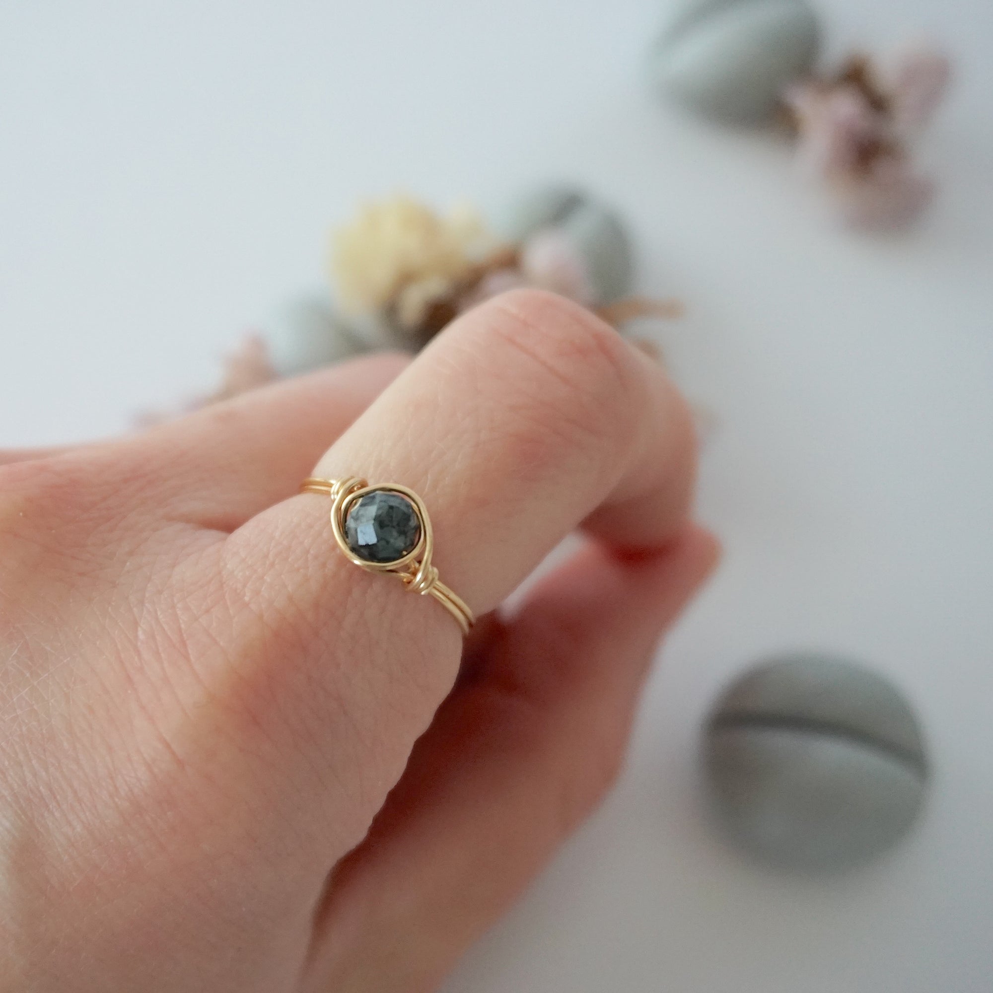 Minimalist gold emerald ring on a model's hand by Designs by Nature Gems, handcrafted May birthstone ring for women.