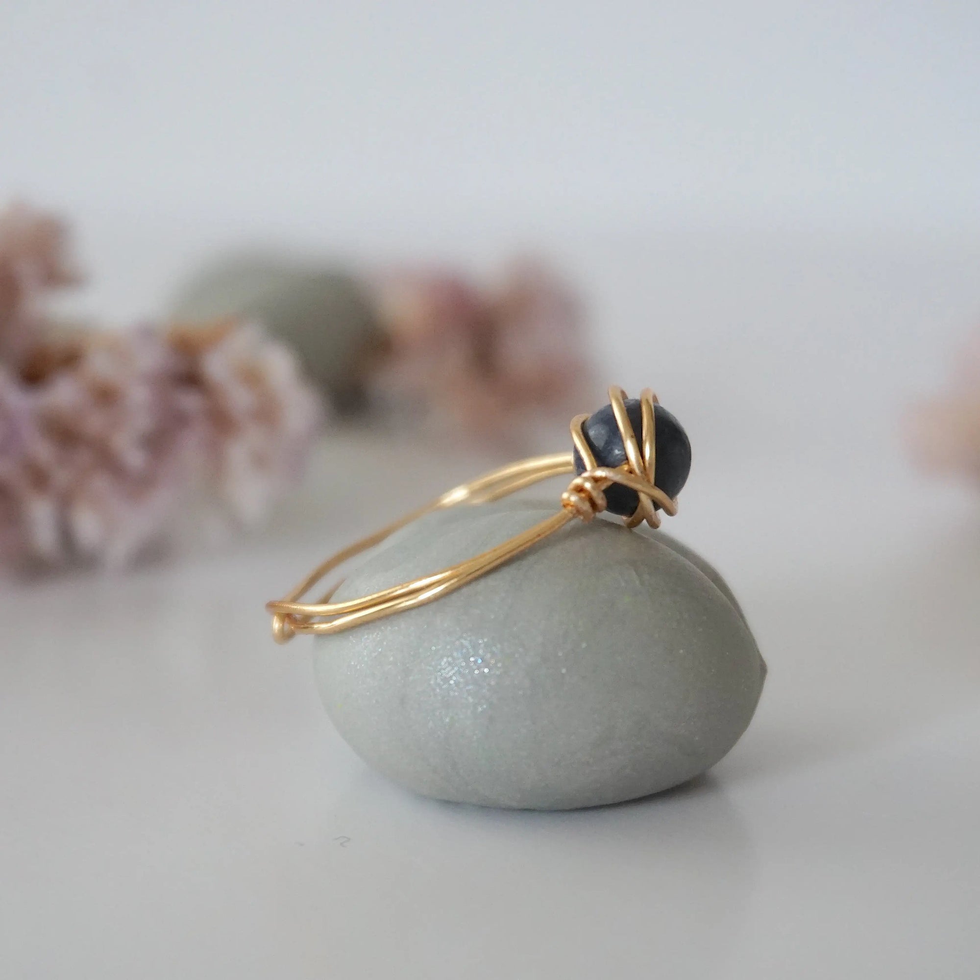Side-angle detail of gold sapphire ring showing the minimalist wire-wrapped setting and natural 6mm sapphire bead