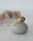 Side-angle detail of gold sapphire ring showing the minimalist wire-wrapped setting and natural 6mm sapphire bead