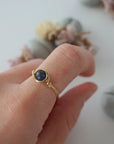Woman wearing a minimalist gold wire-wrapped sapphire birthstone ring — handcrafted women's jewelry by Designs by Nature Gems