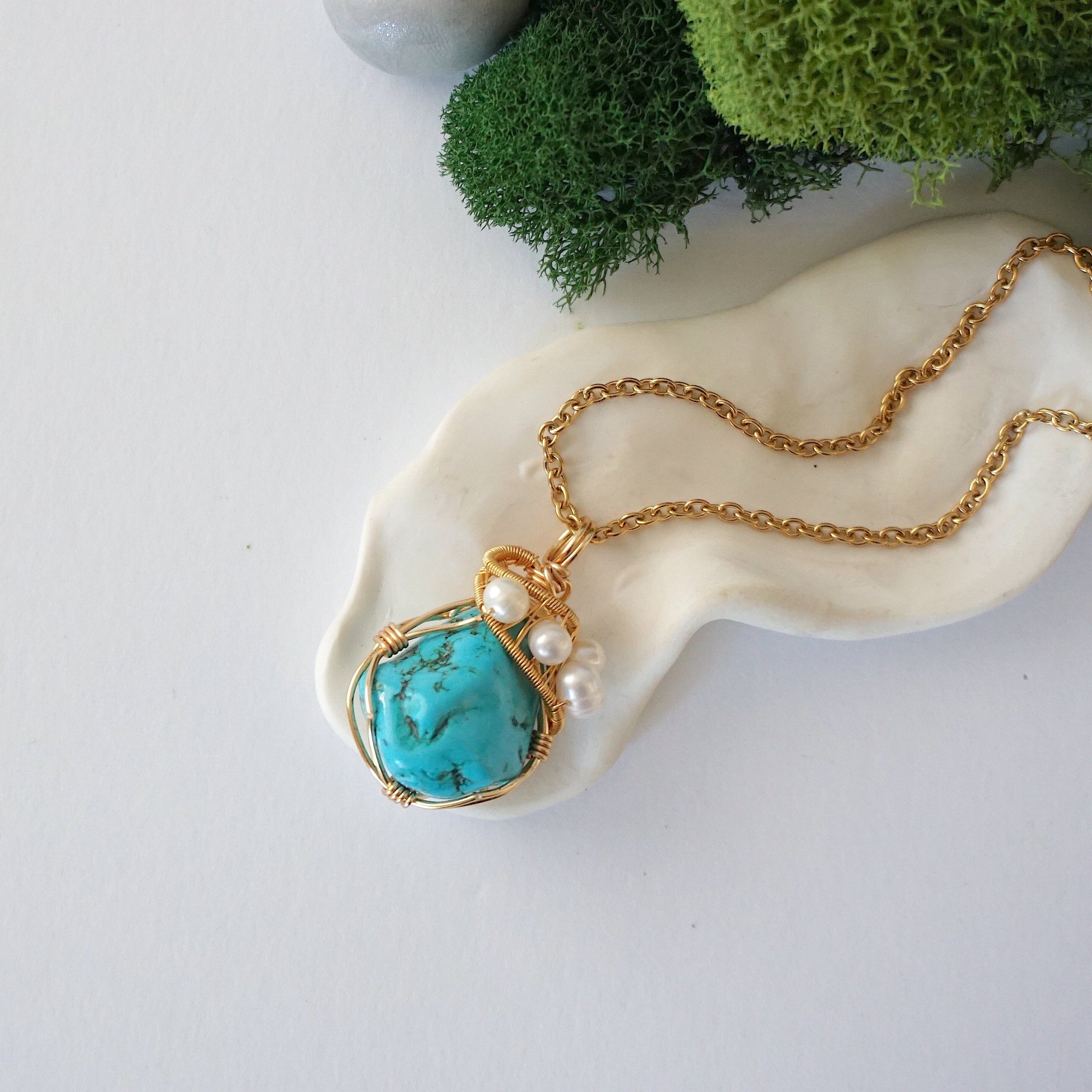 Gold turquoise pearl necklace with raw crystal and freshwater pearl on brass chain, full length flat lay view