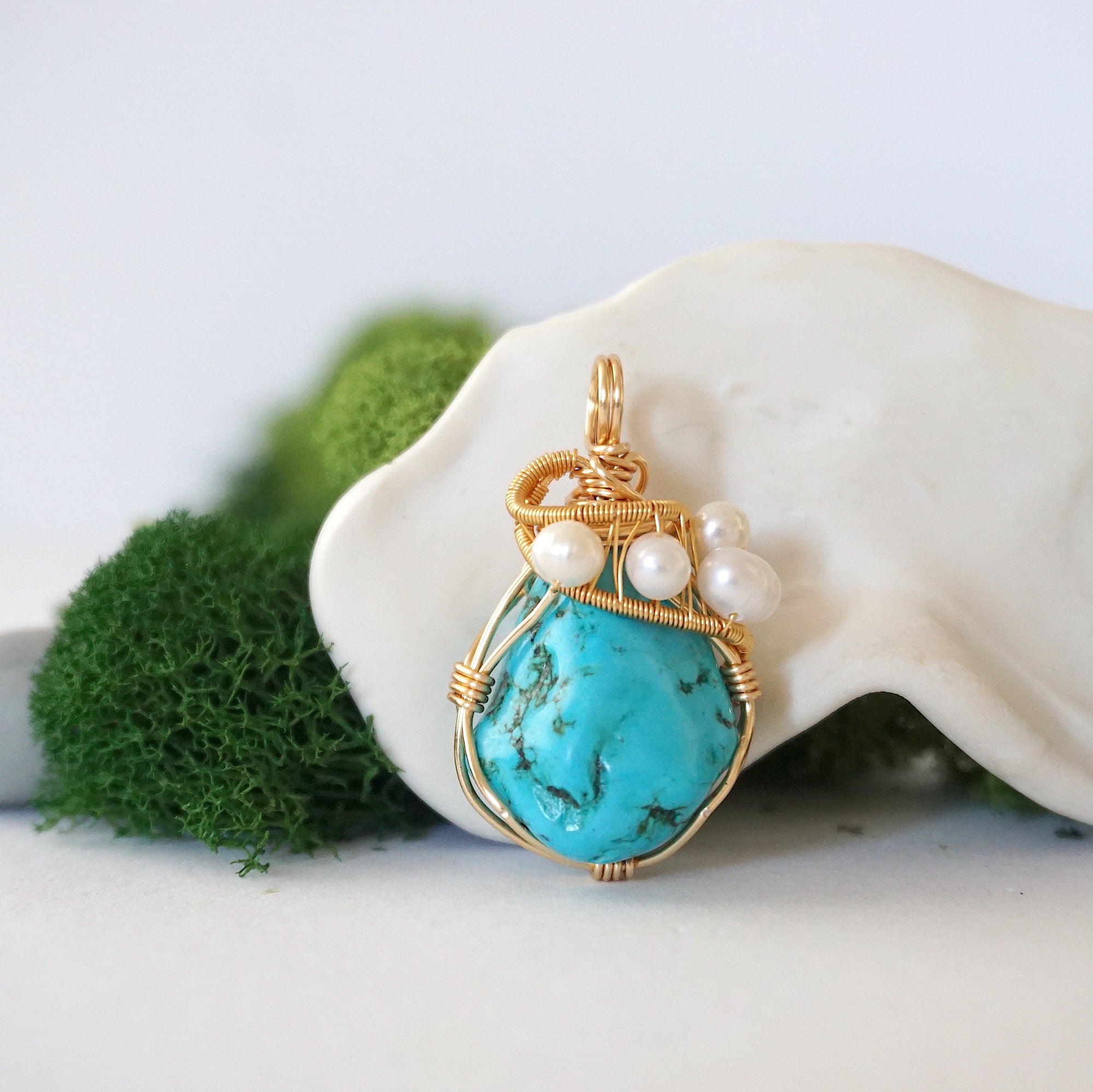 Detailed front view of gold wire wrapped turquoise and freshwater pearl pendant showing artisan craftsmanship