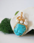 Side angle of raw turquoise and pearl pendant showing wire wrapping depth and natural crystal texture