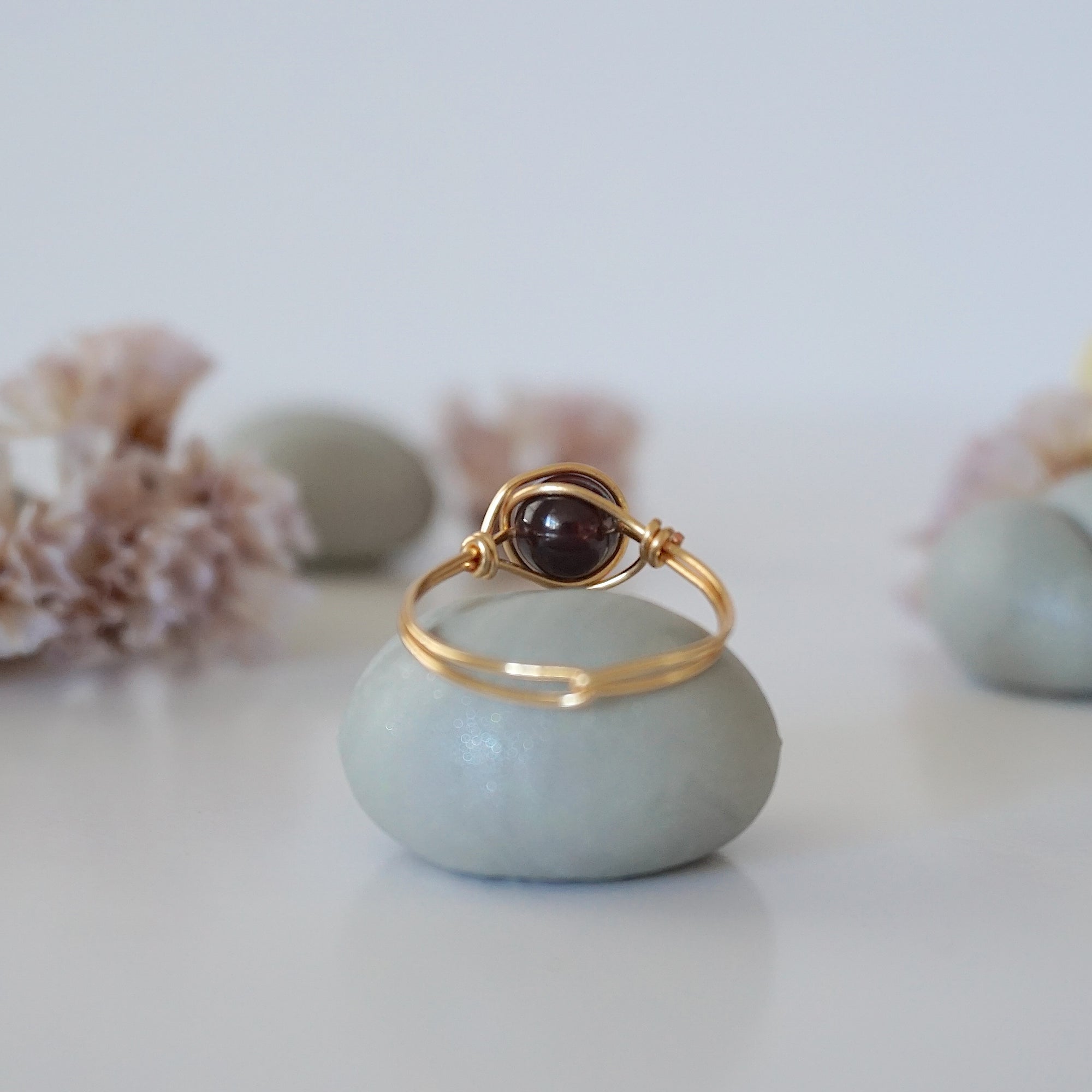 Back view of simple gold wire wrapped garnet ring with clean minimalist band design