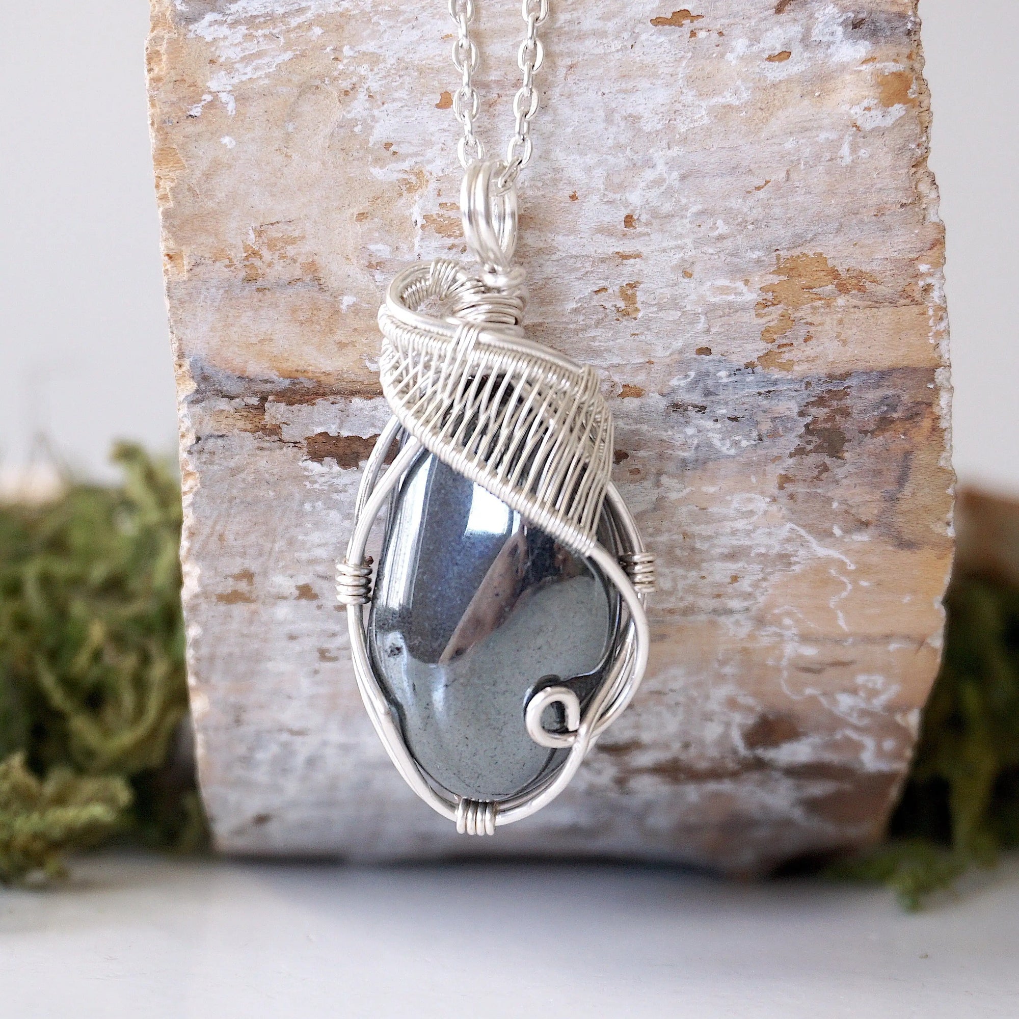 Front view of natural polished-raw hematite pendant necklace with detailed soft silver over copper wire wrapping