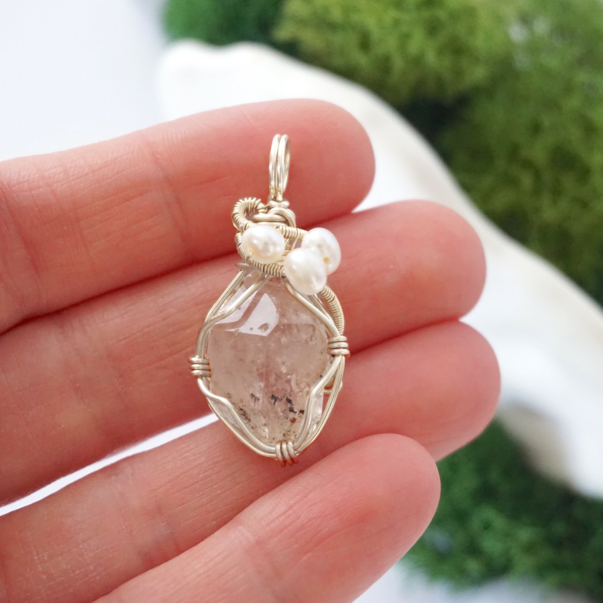 Herkimer diamond and freshwater pearl pendant necklace in hand for size reference, silver wire wrapped, handcrafted gemstone jewelry