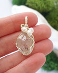 Herkimer diamond and freshwater pearl pendant necklace in hand for size reference, silver wire wrapped, handcrafted gemstone jewelry