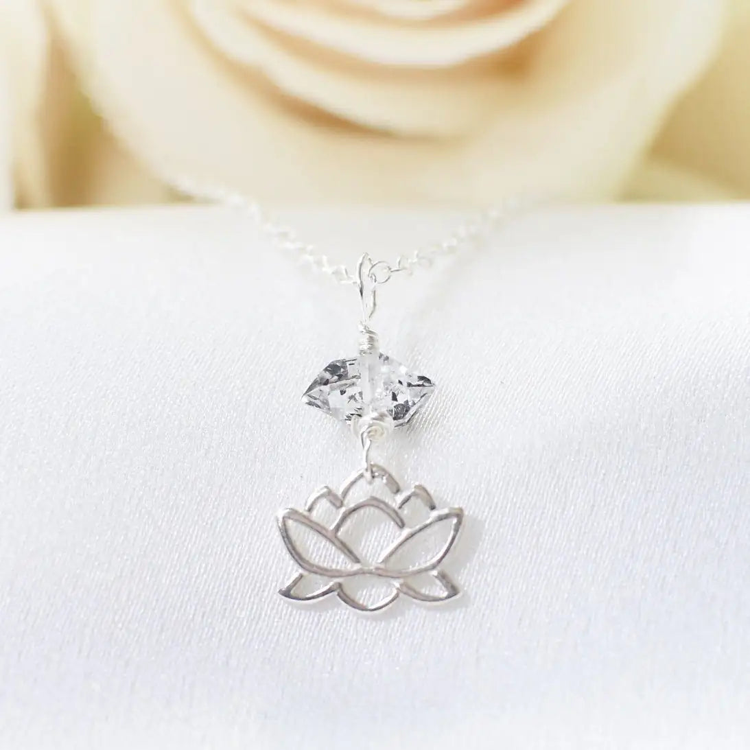 Detailed view of Herkimer diamond and lotus necklace in 925 sterling silver with natural raw crystal and symbolic lotus charm.