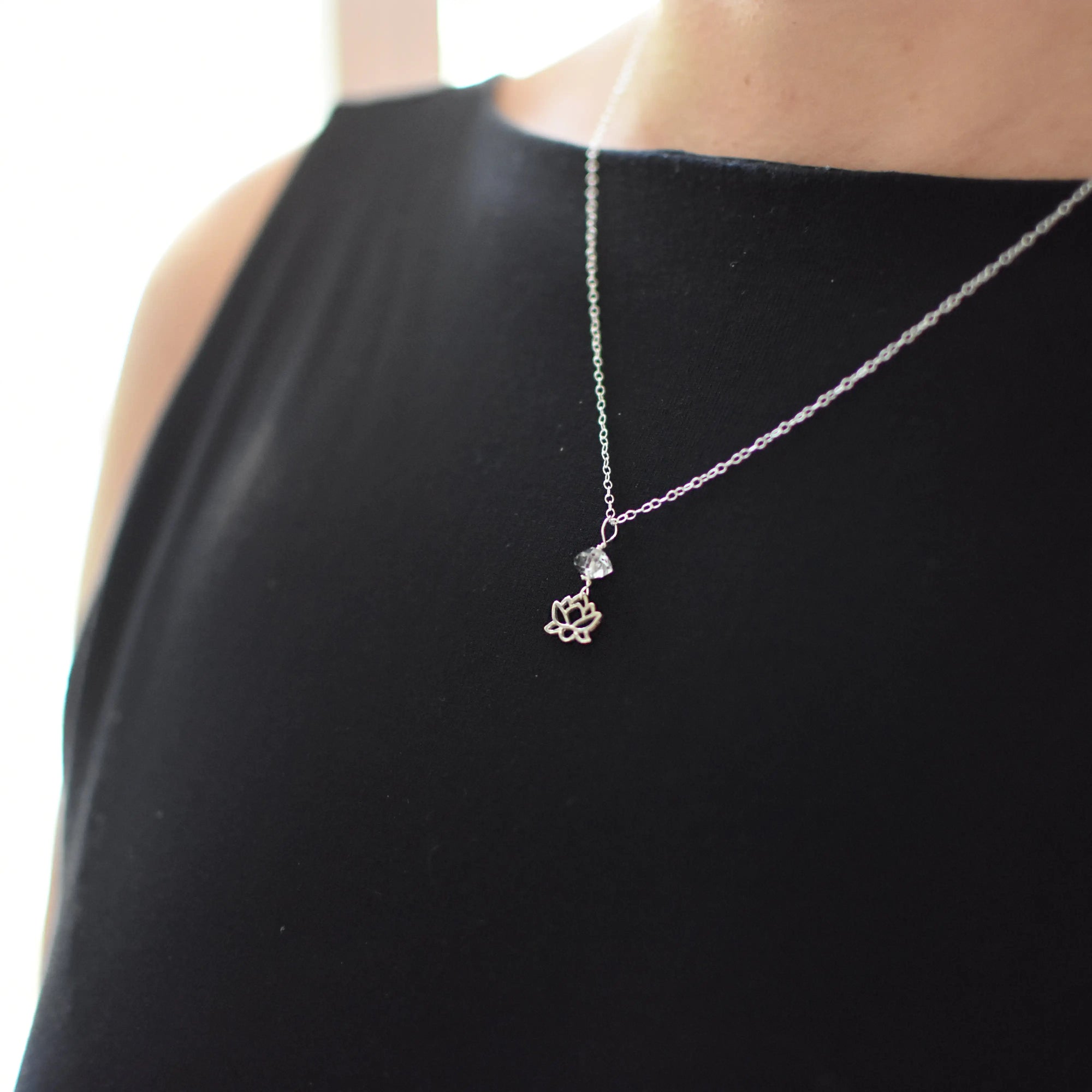 Herkimer diamond and lotus necklace in 925 sterling silver worn on a female model.