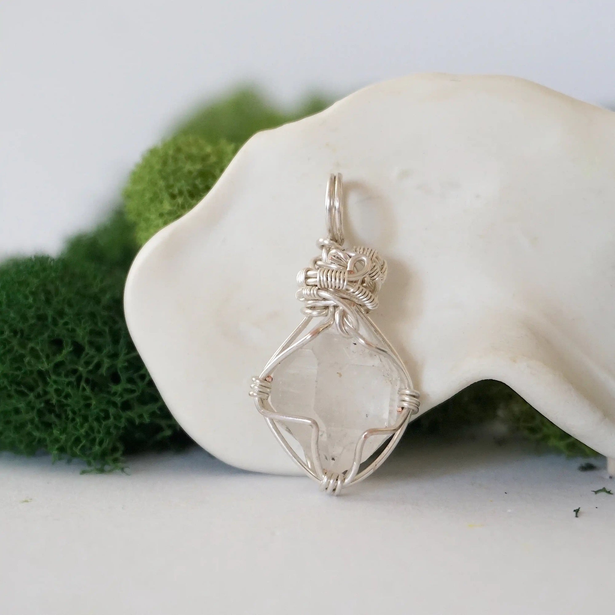 Back angle detail of raw Herkimer diamond pendant with intricate artisan wire wrapping in soft silver copper.