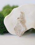 Front angle view of raw Herkimer diamond pendant in soft silver copper with detailed artisan wire wrapping.