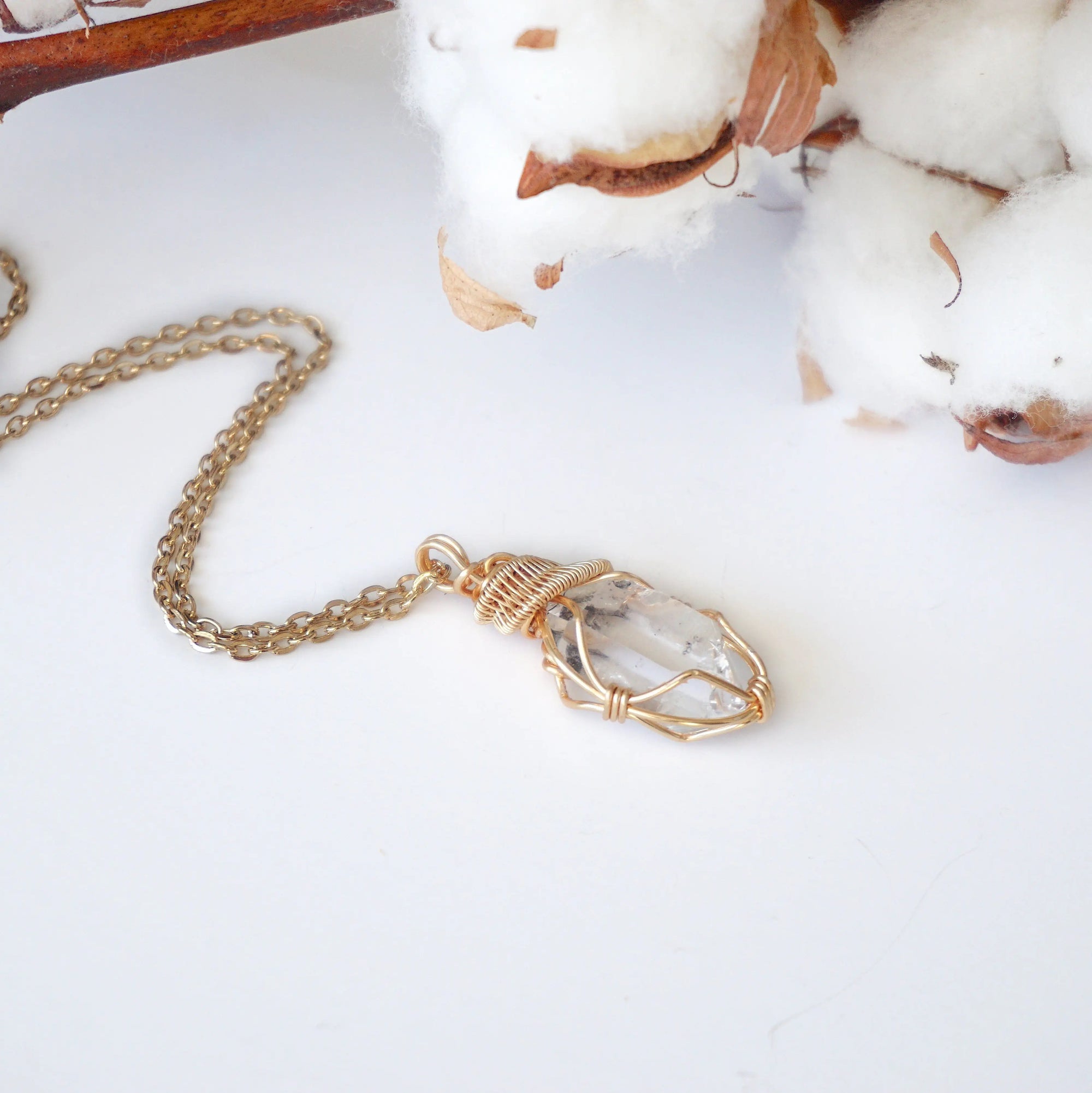 Raw Herkimer diamond pendant on gold plated brass chain with handmade warm gold copper wire wrapping.