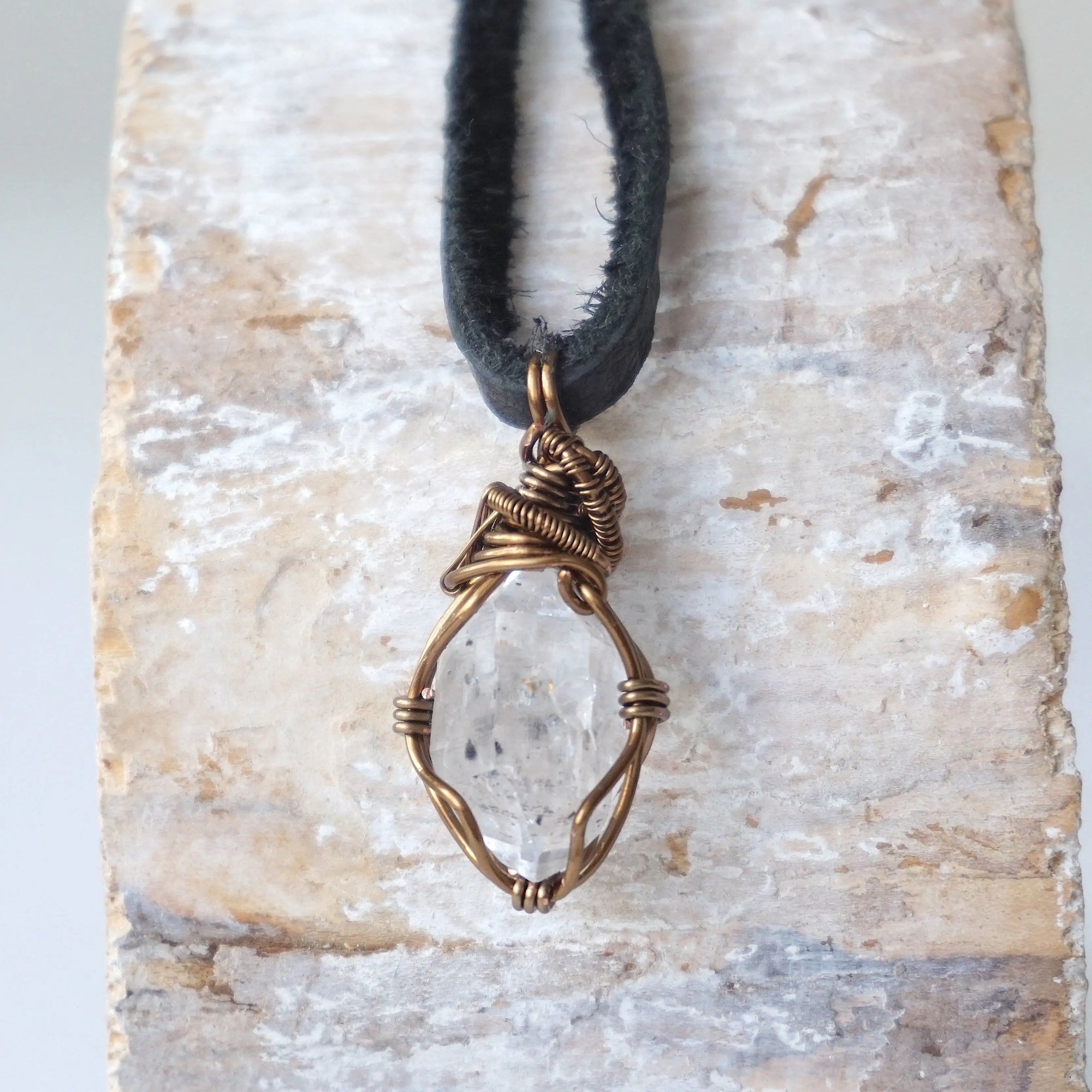 Back angle detail of raw Herkimer diamond pendant for men with intricate artisan wire wrapping in antique bronze copper.