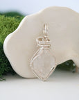 Right angle view of raw Herkimer diamond pendant showing detailed artisan wire wrapping in soft silver copper.