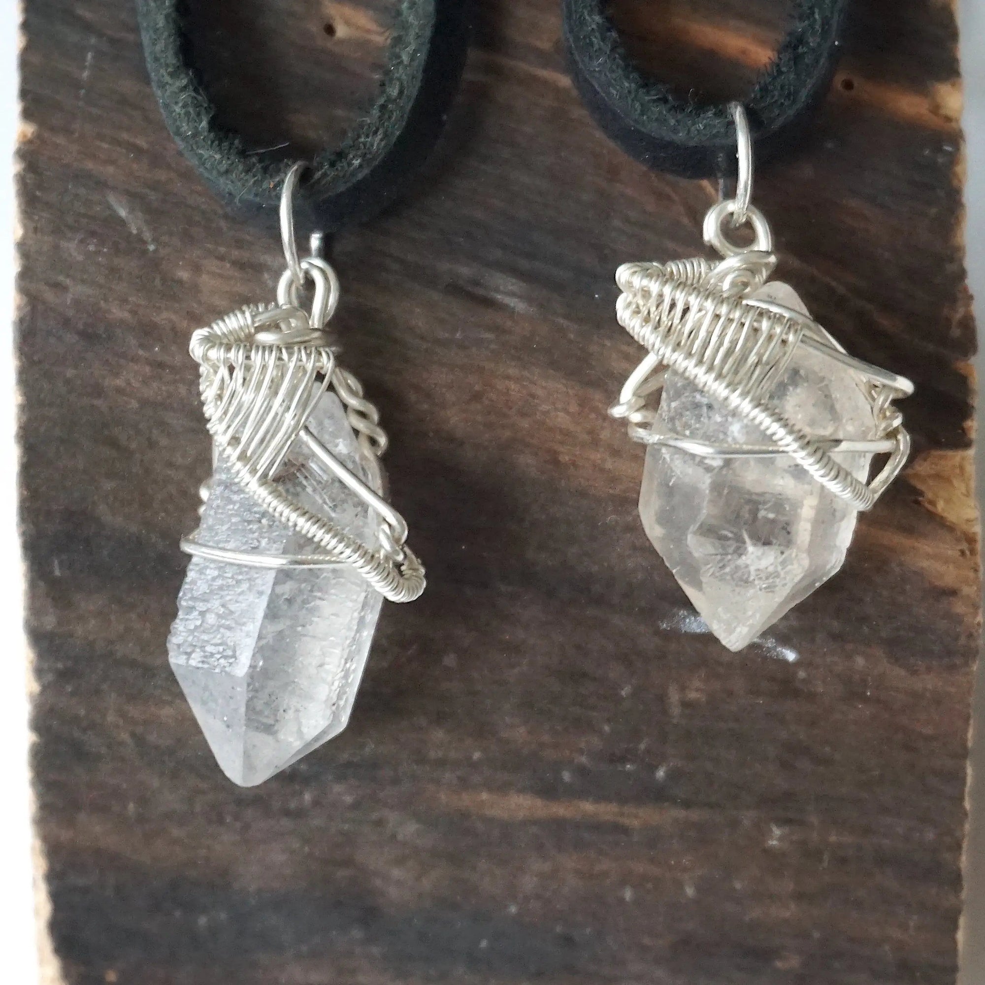 Two Herkimer diamond pendants for men showing natural variation in crystal size, shape, and handcrafted sterling silver wire wrapping.