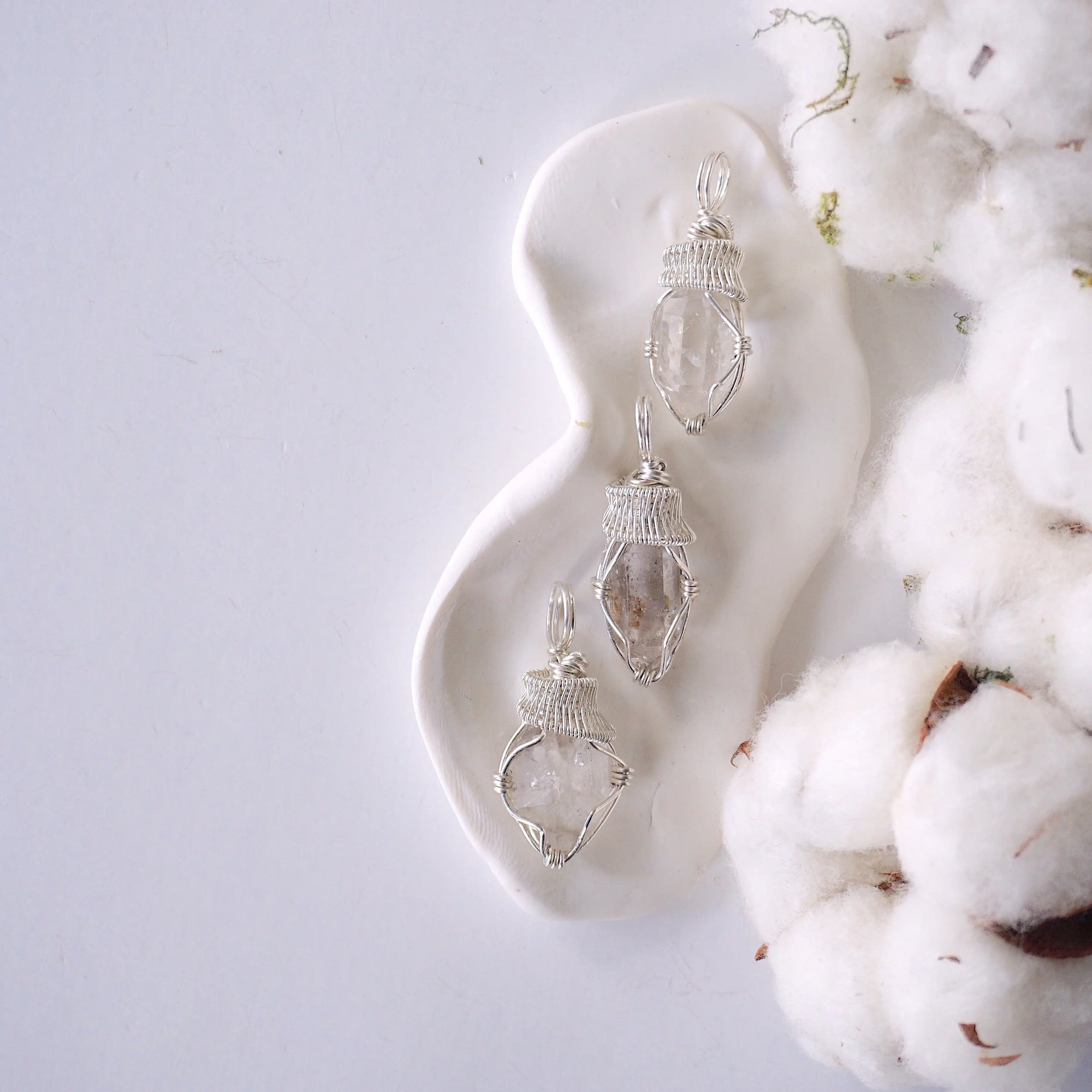 Three raw Herkimer diamond pendants for women showing natural variation in crystal shape, size, and artisan wrapping.