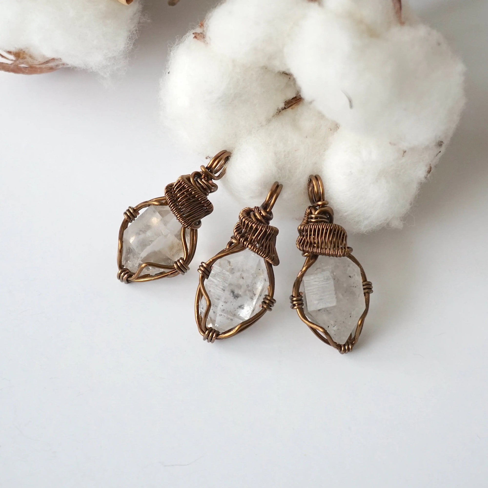 Three raw Herkimer diamond pendants for women showing natural variation in crystal shape, size, and artisan wrapping.