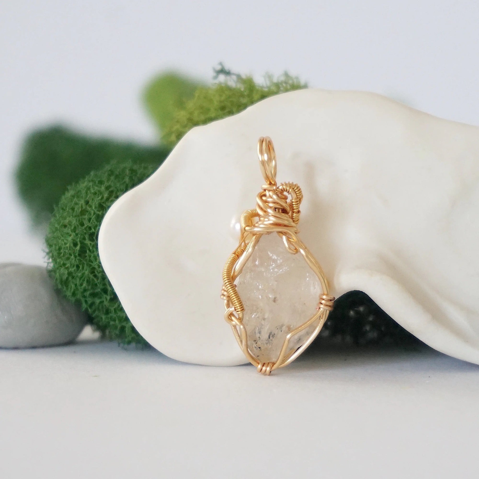 Back angle detail of herkimer diamond and freshwater pearl pendant, showing wire wrapping and natural stone