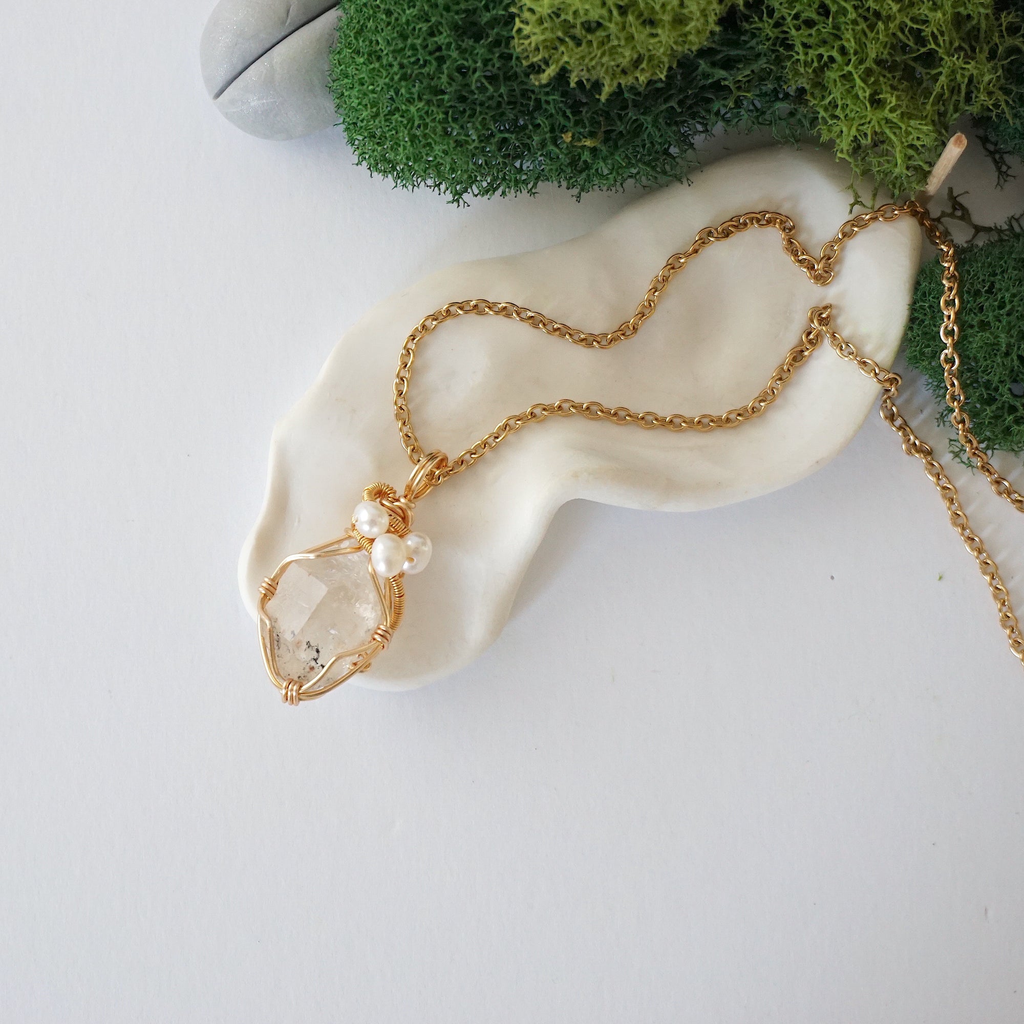 Herkimer diamond and freshwater pearl pendant on gold plated brass chain laying flat, handmade wire wrapped jewelry for women