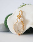 Side angle detail of herkimer diamond and freshwater pearl pendant, gold wire wrapped, ethical artisan necklace