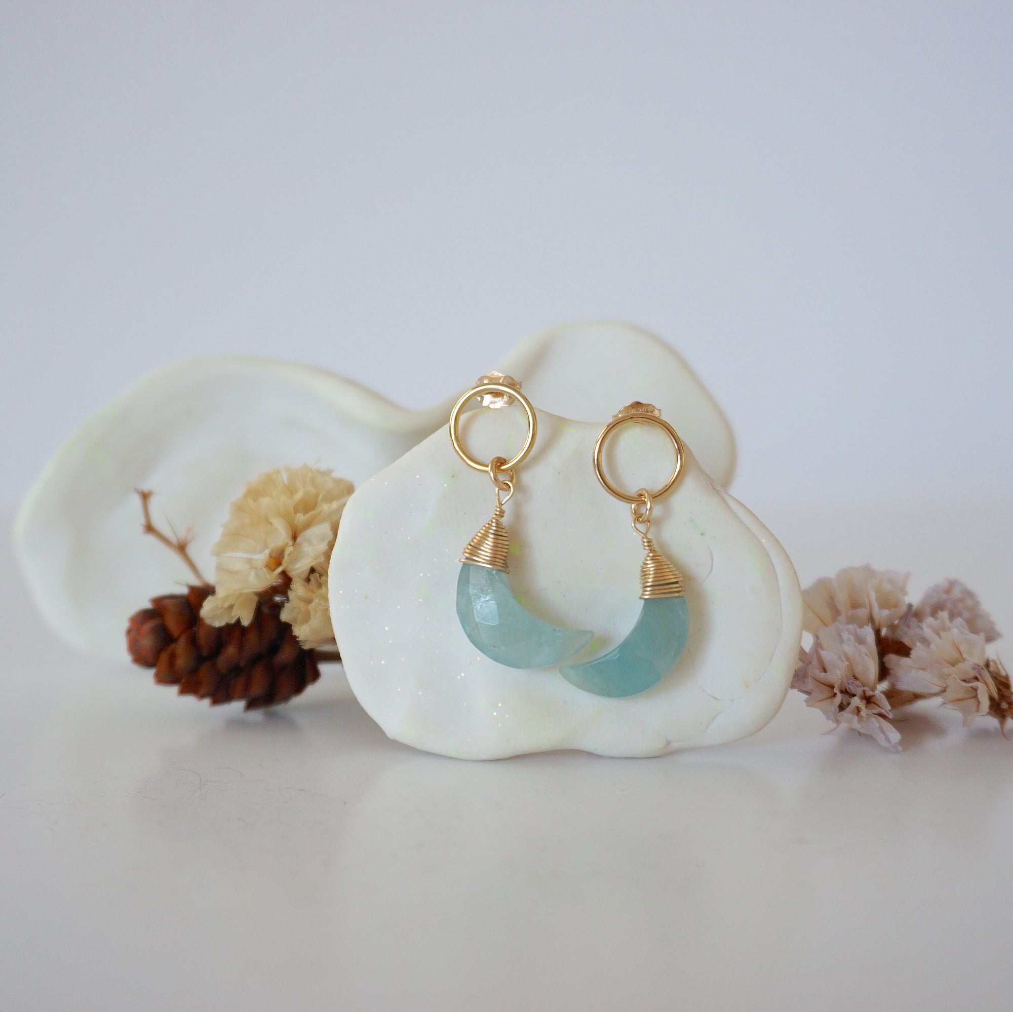 Front angle look at Lux Aquamarine Moon Open Circle Stud Earrings on jewelry display, faceted natural aquamarine, gold filled, handmade.