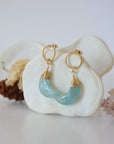 Side angle view of Aquamarine Moon Open Circle Stud Earrings hanging on jewelry display, minimalist 14k gold filled wire wrap, limited edition.