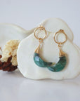 Detailed close-up of Lux Limited Edition Emerald Moon Open Circle Stud Earrings on jewelry display, faceted natural emerald, 14k gold filled, handmade.