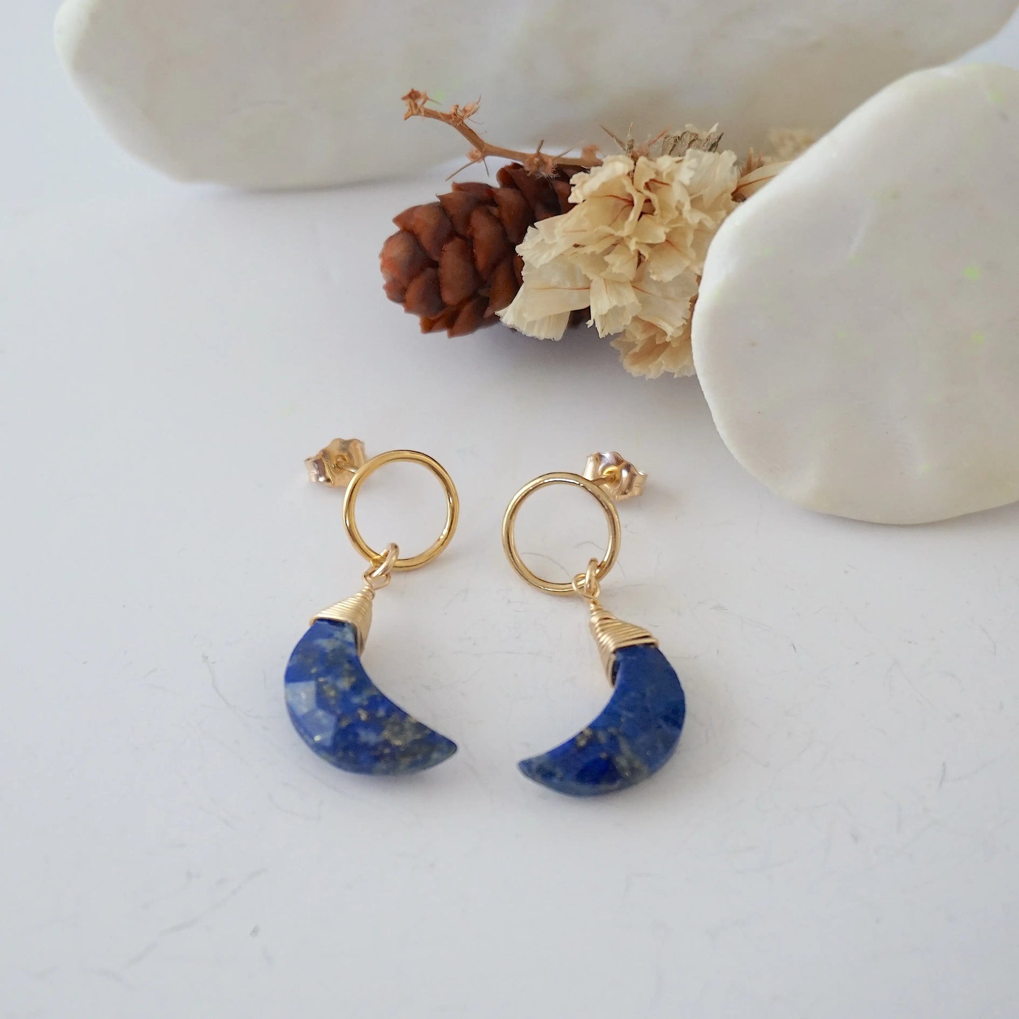 Lapis Lazuli Moon Open Circle Stud Earrings laying flat, 14k gold filled minimalist wire wrap, natural faceted lapis lazuli, limited edition.