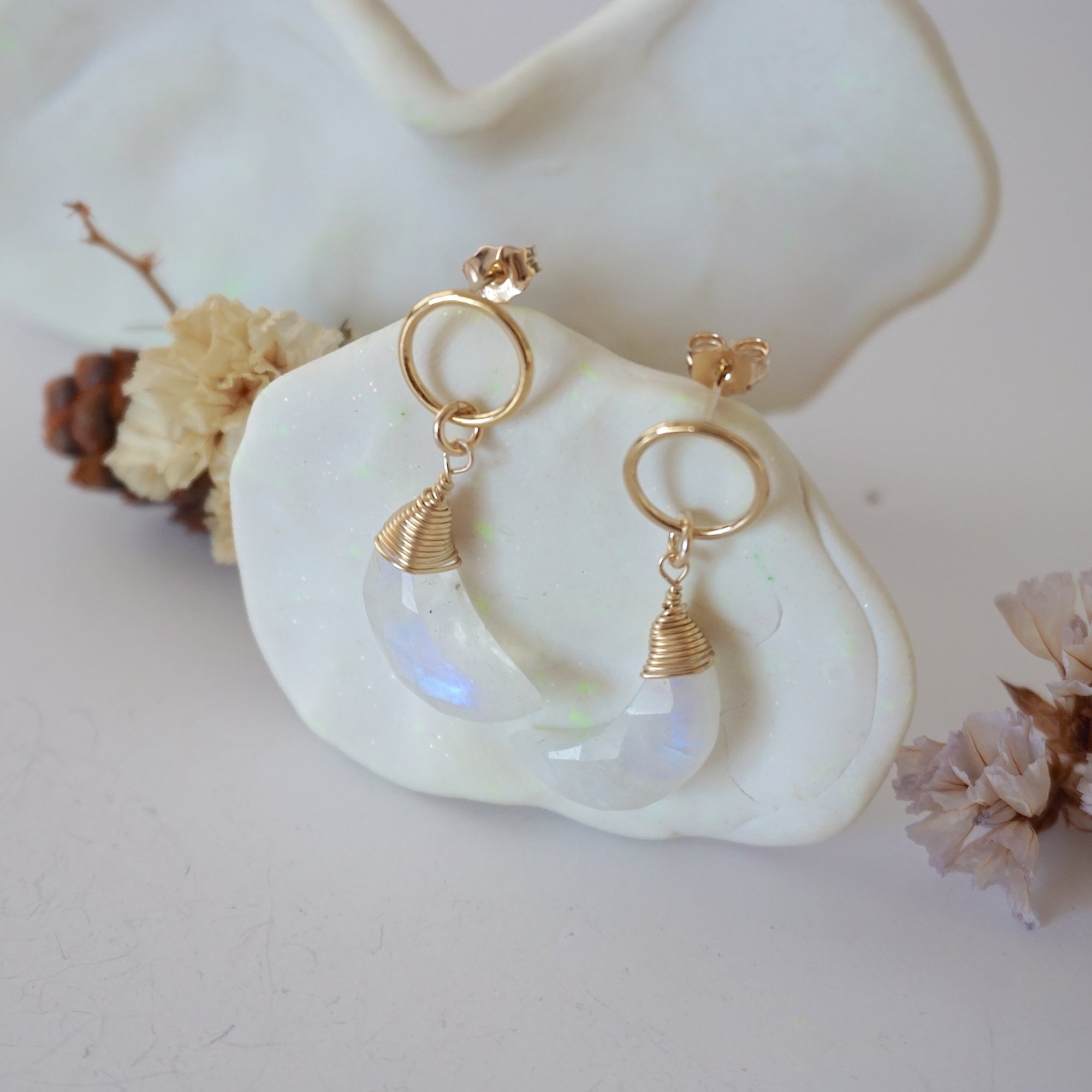 Side angle view of Rainbow Moonstone Moon Open Circle Stud Earrings hanging on jewelry display, minimalist 14k gold filled wire wrap, limited edition.