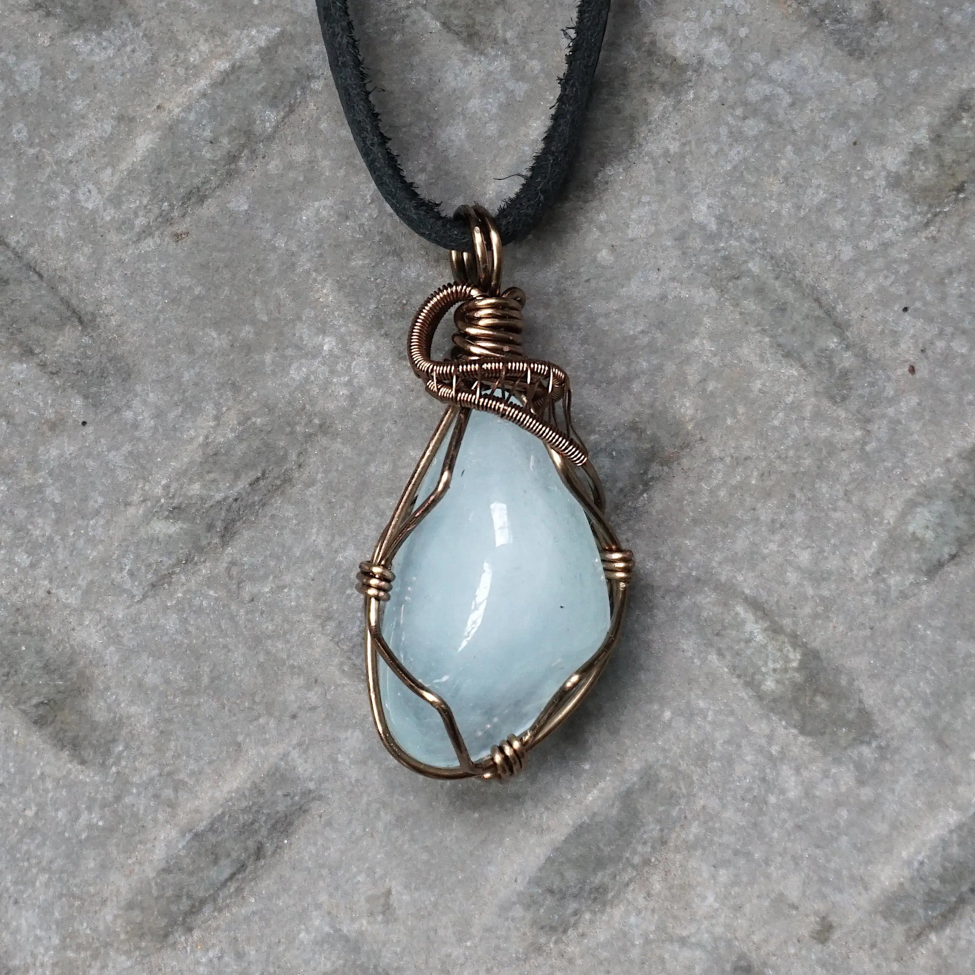 Men's aquamarine necklace with genuine polished aquamarine pendant, detailed front view, artisan wire wrapped in antique bronze copper, flat black leather cord, Designs by Nature Gems