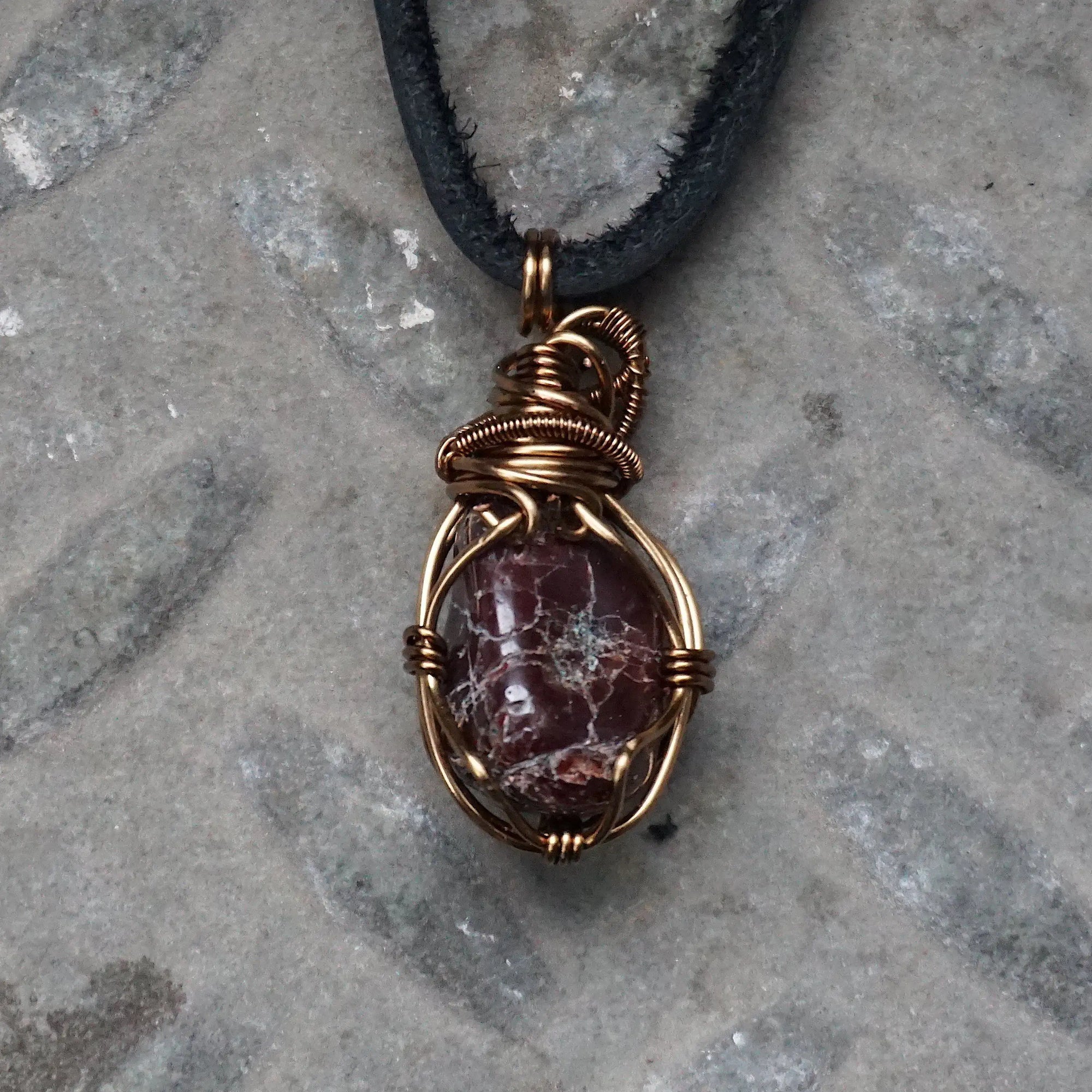 Back view of a men’s garnet wire wrapped pendant necklace in antique bronze copper, highlighting the handcrafted wire work