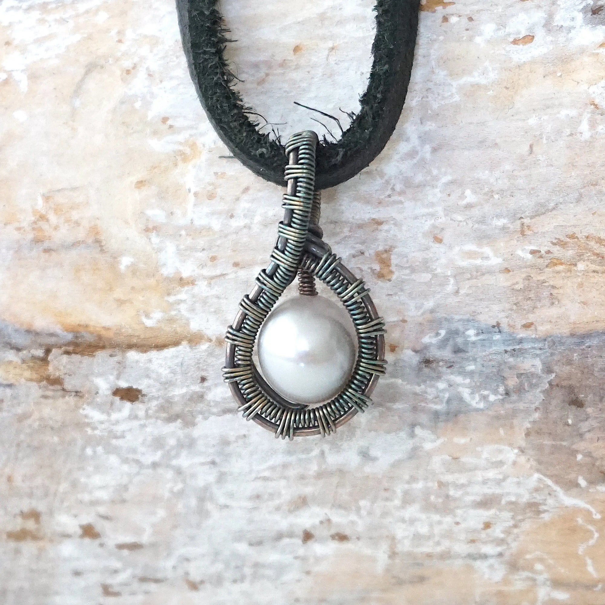 Men’s pearl pendant necklace with a natural freshwater pearl on a black leather cord, shown in full view
