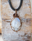 Men’s rainbow moonstone necklace with natural polished-raw pendant, antique bronze copper wire wrap and flat black leather cord
