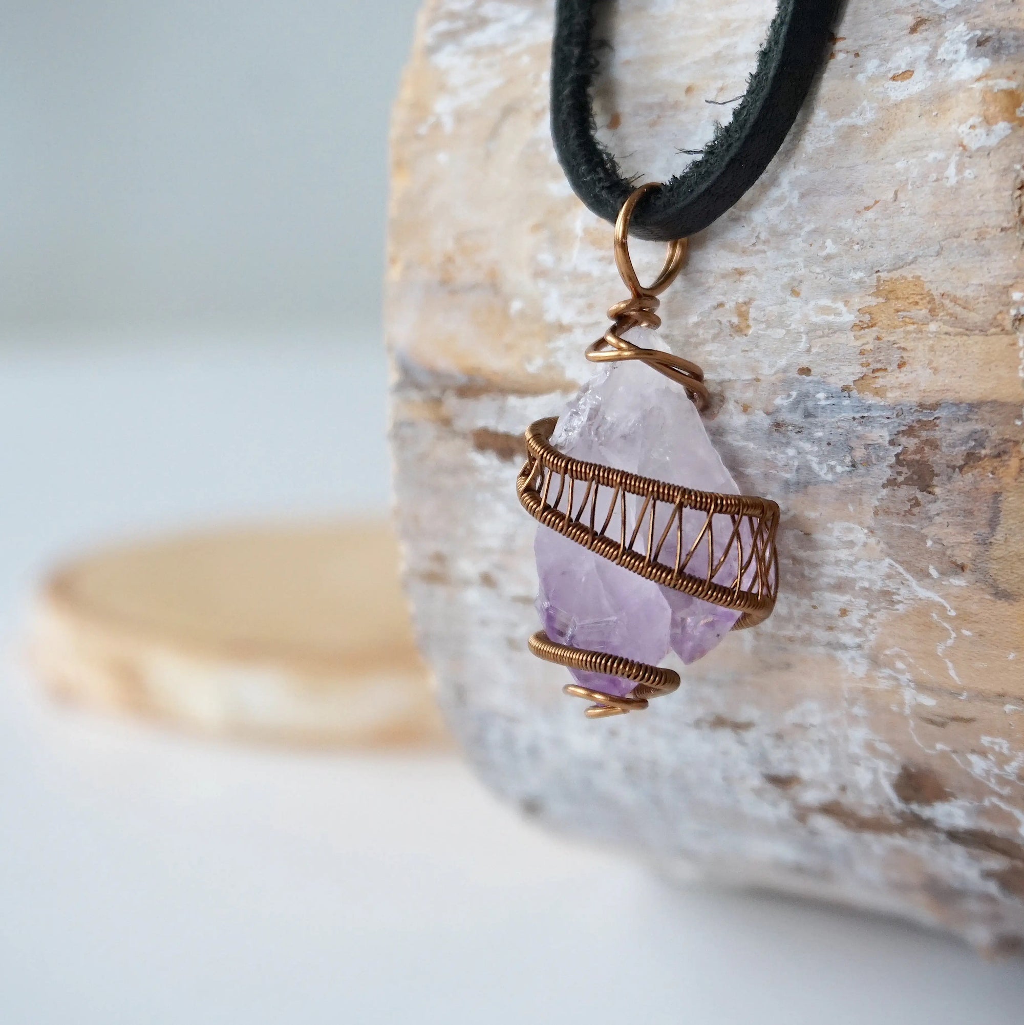 Left side view of men’s raw amethyst pendant in antique bronze copper wire wrap on black leather cord, natural crystal necklace