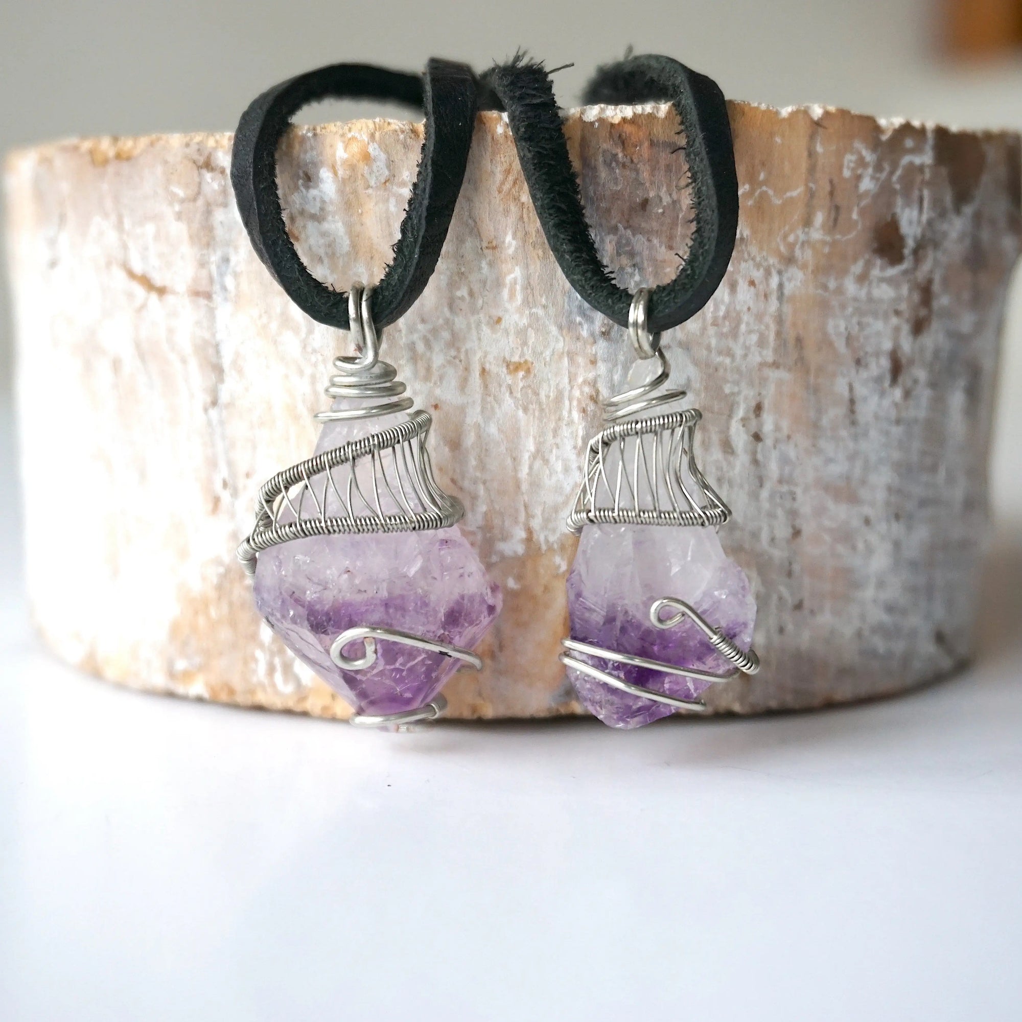 Two men’s raw amethyst pendant necklaces on black leather cord showing natural variation in amethyst size, shape, and color