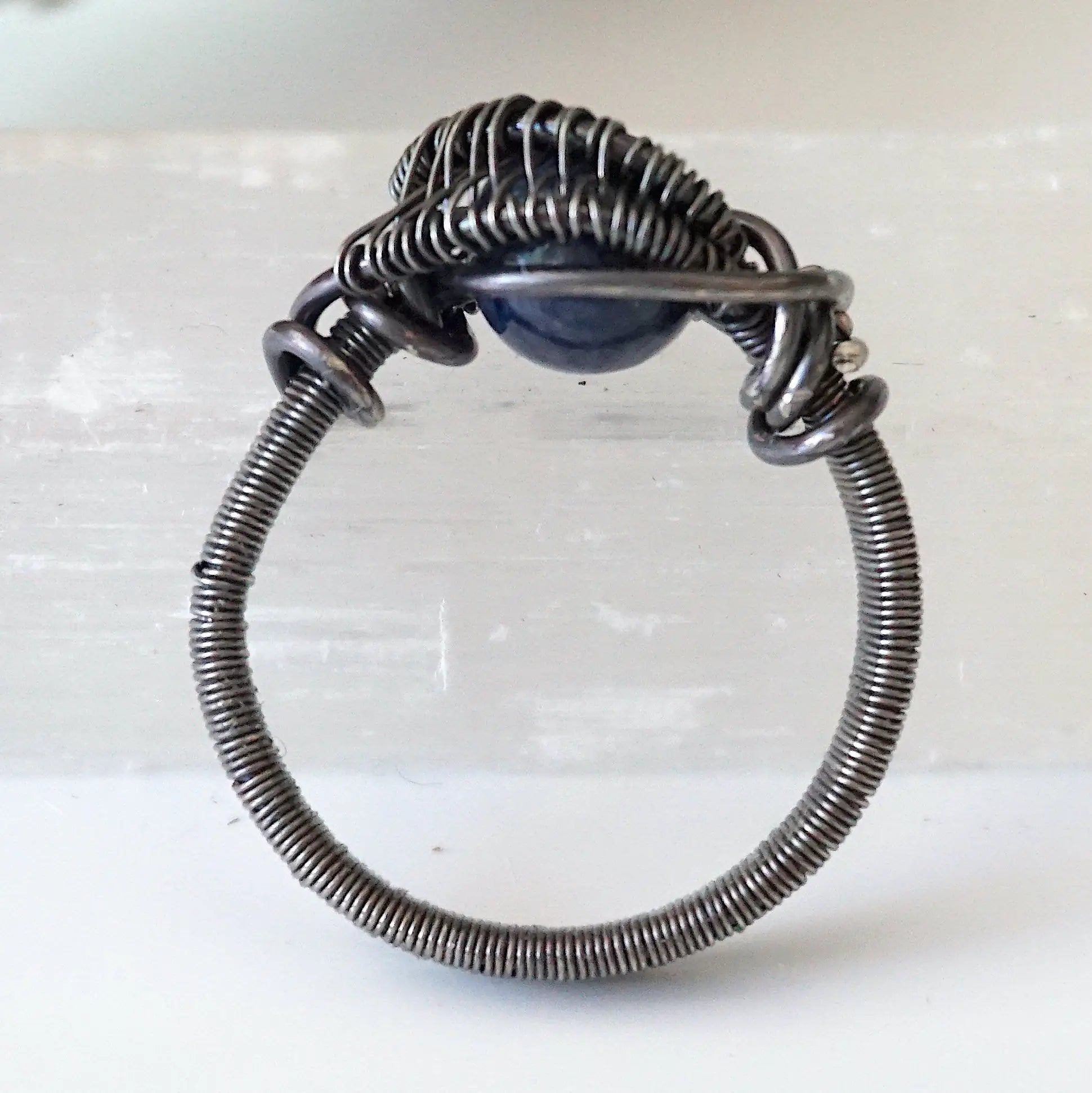 Detail of approximately 4mm men's sapphire ring band with antiqued 925 sterling silver wire-wrapped artisan finish