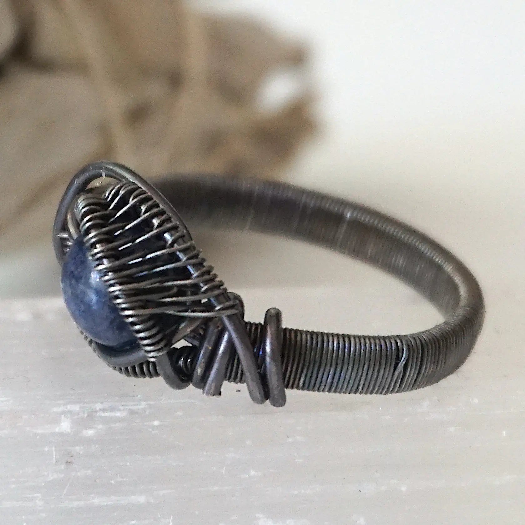 Side-angle detail of men's sapphire ring showing the artisan wire wrapping in antiqued 925 sterling silver