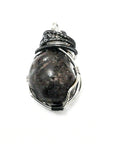 Close-up side view of a men’s wire wrapped garnet pendant highlighting the handcrafted mixed metal copper wire detail