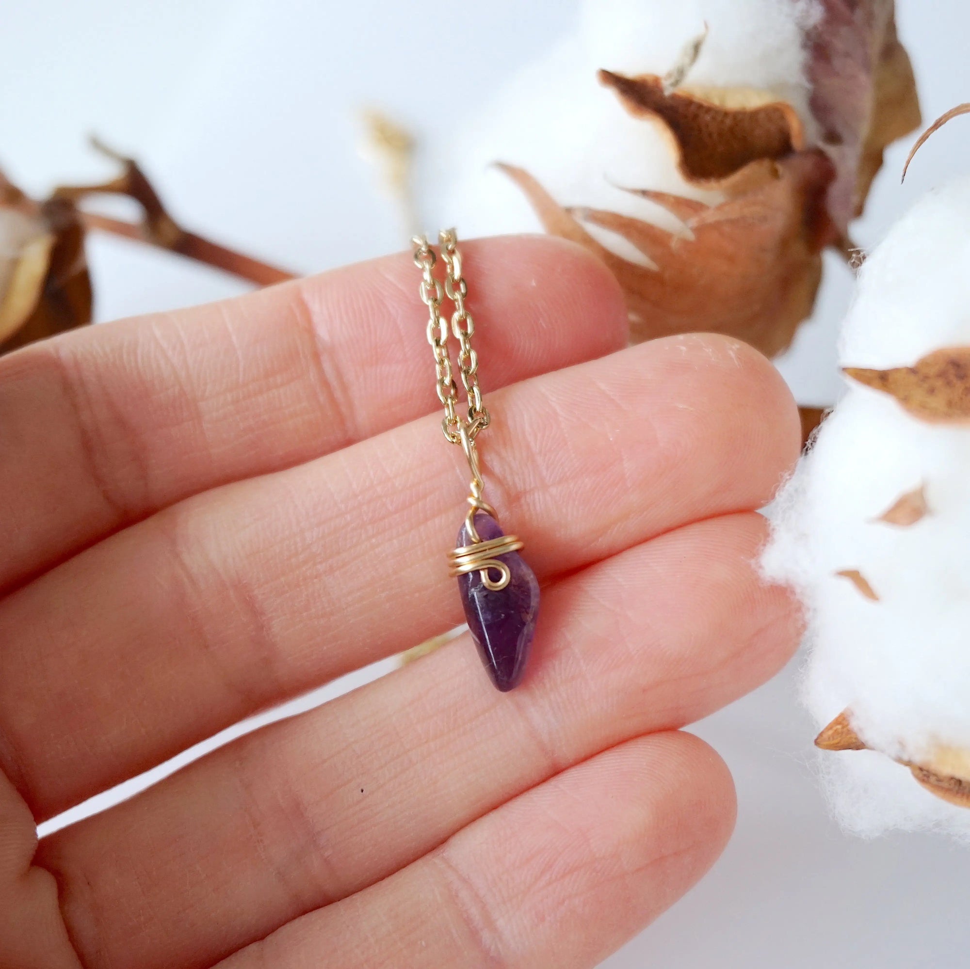 Minimalist amethyst necklace for women shown in hand for size reference, gold plated copper wire wrap