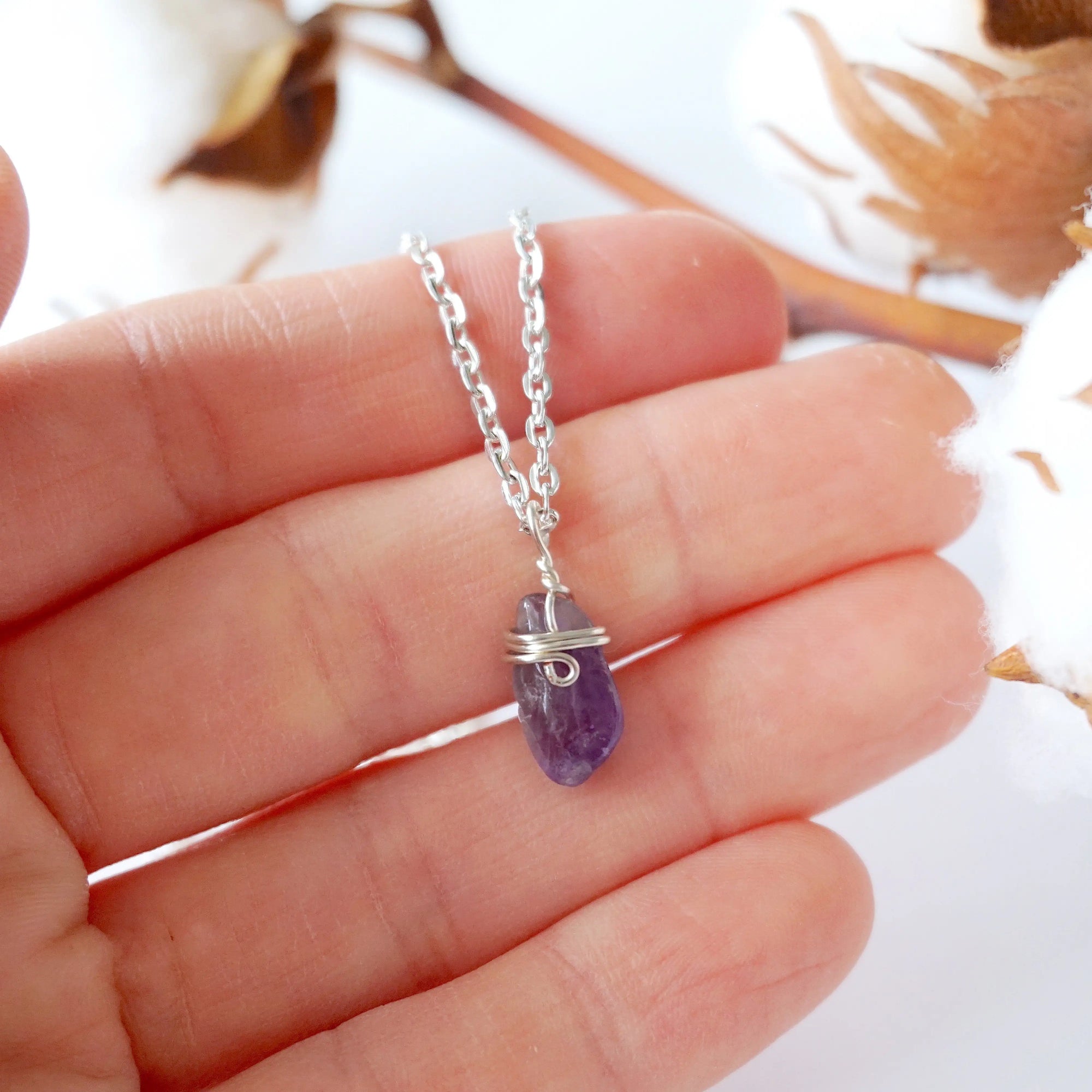 Minimalist amethyst necklace for women shown in hand for size reference, silver plated copper wire wrap