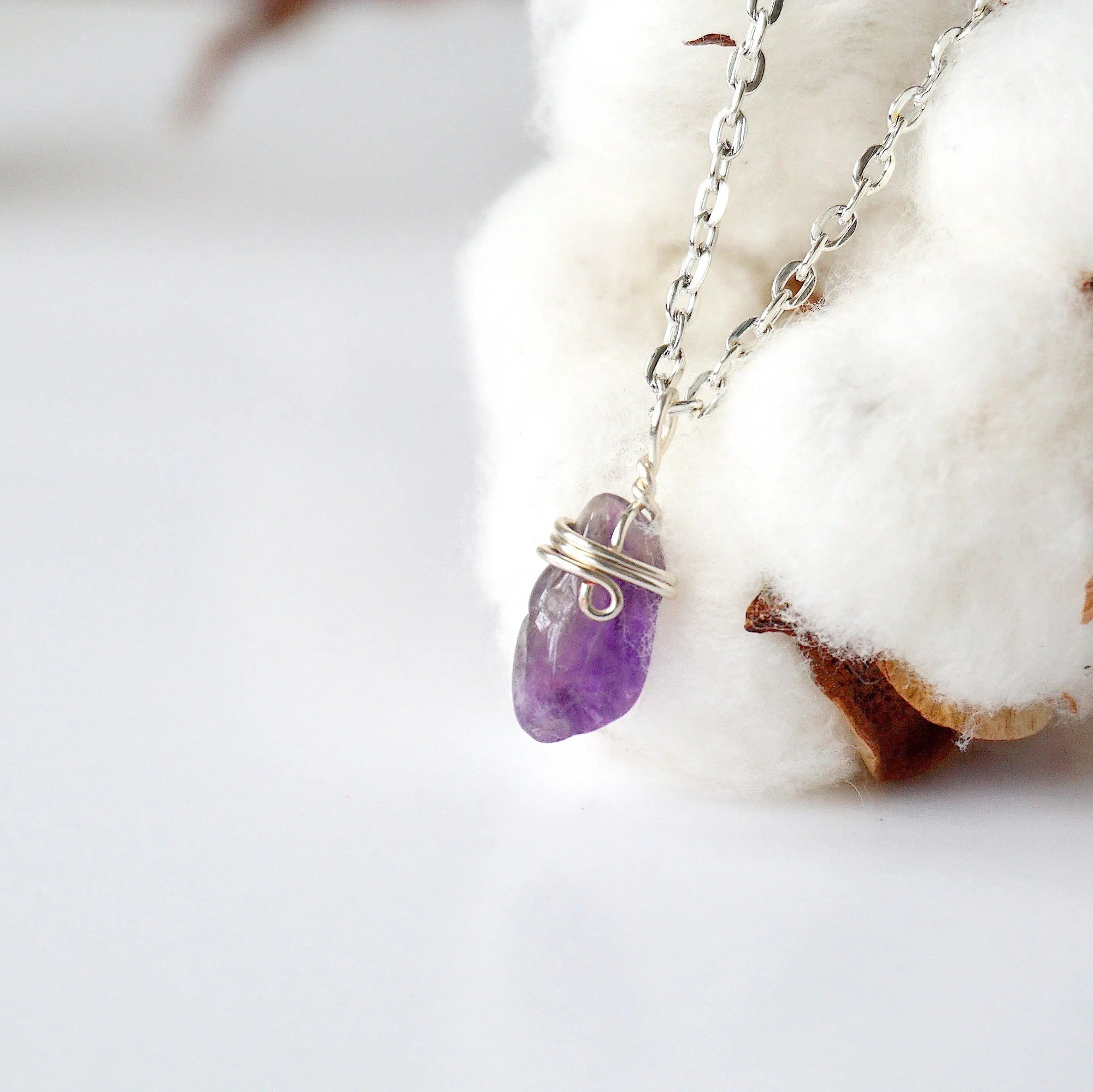 Left side angle of minimalist amethyst necklace for women, silver plated copper wire wrapped raw amethyst pendant