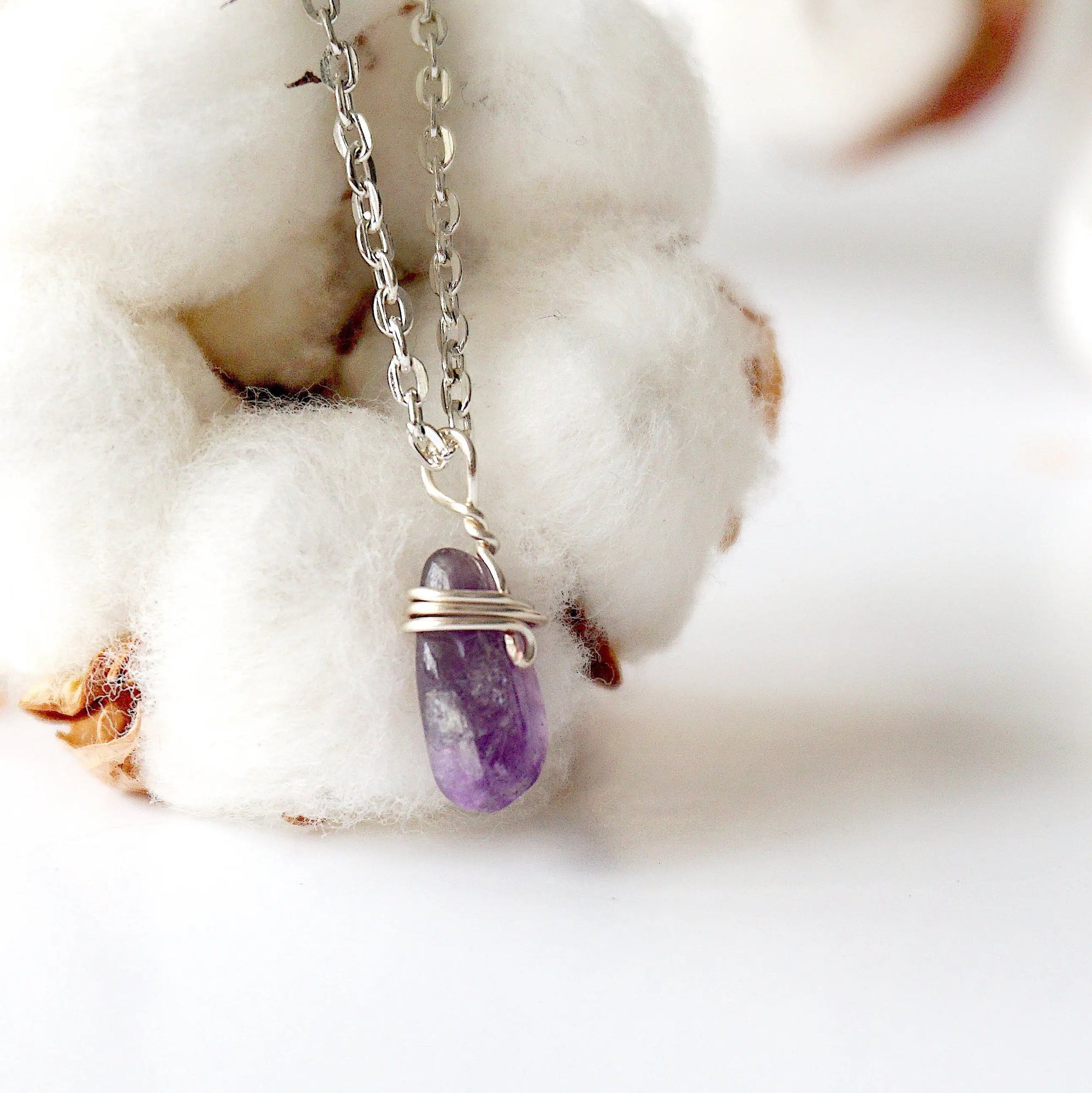 Right side angle of minimalist amethyst necklace, raw amethyst pendant wire wrapped in silver plated copper